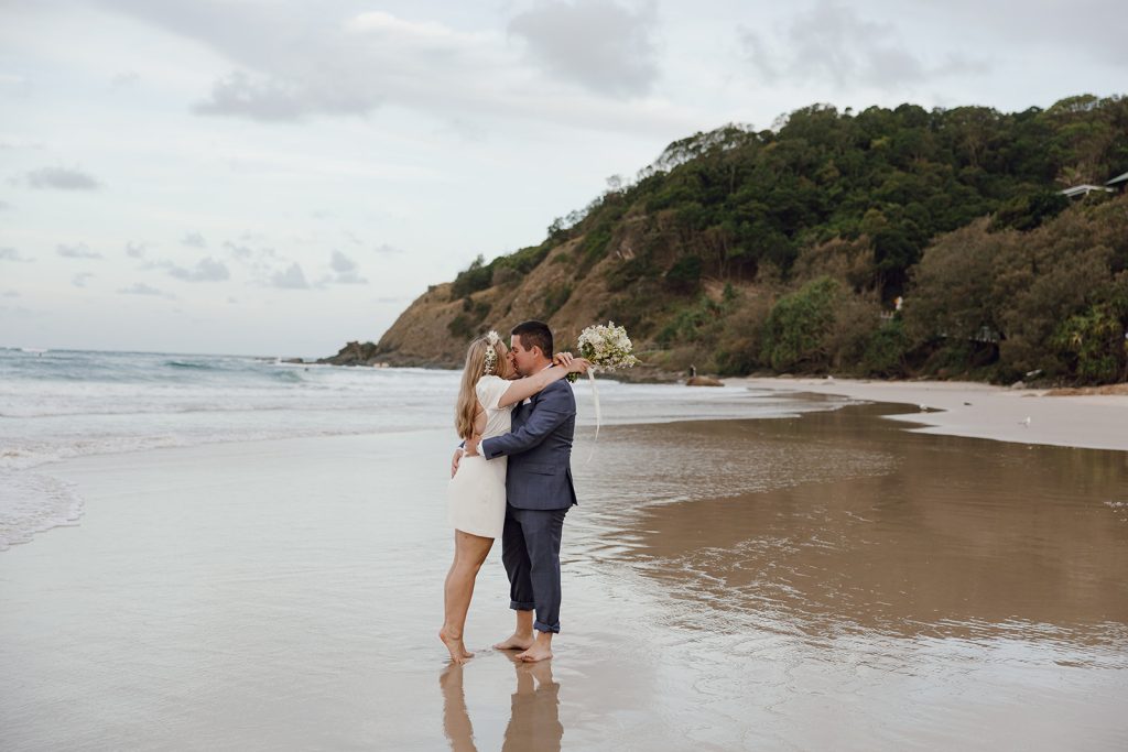 Newlyweds kissing at Wategos beach